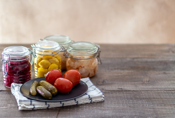 Pickled cucumbers and tomatoes on the black plate. Fermented veggies. Copy space.