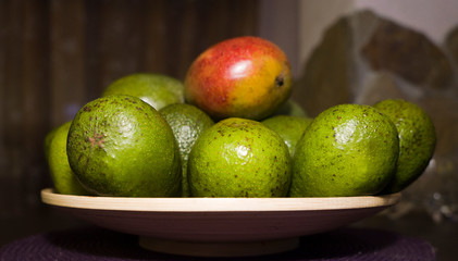 avocado and mango on a wooden plate