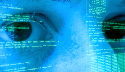 The eyes of a woman (a computer programmer) looking at the camera, with source code (program...