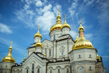 Fototapeta na wymiar Pochaev Lavra. Domes of Pochaevskaya Lavra against a blue sky with beautiful clouds. Coronavirus.