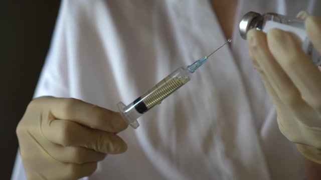 Self-injection of antibiotics. Female preparing needle for injecting her buttocks. Woman injecting buttocks.