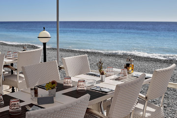 The table for the company or business lunch on the shore of a calm sea on a Sunny day.