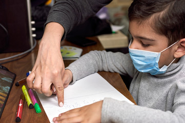 Distance education. Mother helps a pre-school kid to do lessons