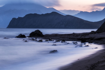  landscape at sunset with sea beach and mountain on the horizon
