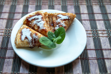 pancakes on a white plate. Full light breakfast made from organic products. close-up. green leaf of mint.