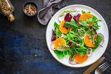 healthy salad tangerines citrus, lettuce, arugula and other herbs. Menu concept food background, keto or paleo diet. top view. copy space for text