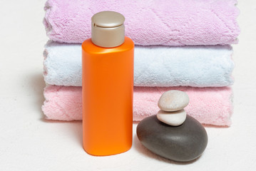 Fototapeta na wymiar Shampoo bottle and pebble stones and towels on white background.