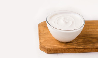 Fototapeta na wymiar Dahi milk Indian sourdough yogurt on a wooden board on a white background. Copy space