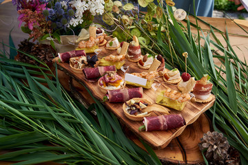 Different canapes with smoked salmon, cucumber, tomatoes, cheese, meat. Breakfast buffet table with...