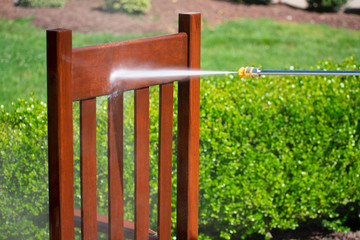 A power washer washing a chair