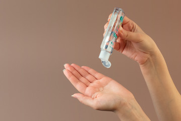 Woman using bottle of antibacterial sanitiser soap gel. Hand sanitizer alcohol gel rub clean hands hygiene prevention of coronavirus virus outbreak. 