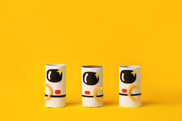 Toys astronaut on yellow background with copy space for text. Concept of business launch, start up, handcraft, diy, creative idea from toilet tube, recycle, kindergarten daycare craft