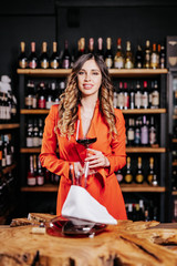 Experienced elegant sommelier woman tastes wine in restaurant. Checking taste, colour, sediments of wine
