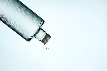 Traditional Turkish cologne dripping from a bottle on white background