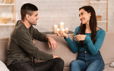 Lovely couple sitting on couch spending time together