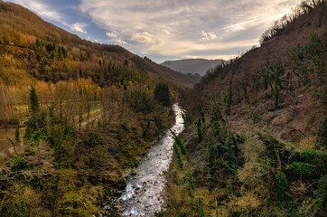 Fototapeta na wymiar Mountain landscape with river running through it