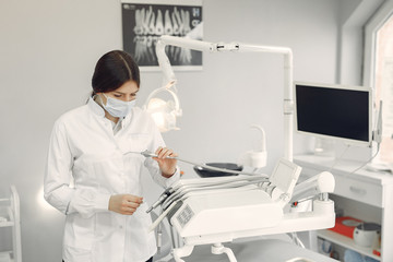 Woman in a uniform. Doctor working at the clinic. Dentist holds a tools in her hands