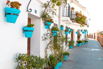 Beautiful view of old Mijas Calle Moro, white houses and aqua blue flower pots. a special and...