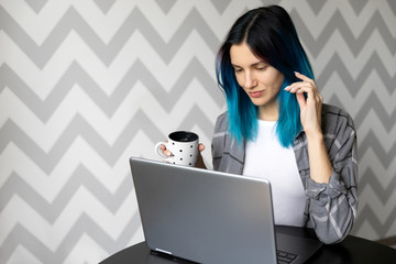 Young adult woman with blue hair working from home office