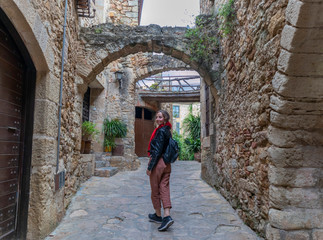 Fototapeta na wymiar Walking and smelling flowers in the beautiful medieval village of Pals on the Catalan coast.