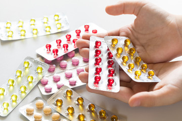 Pills in the blister on the child 's open palms. It is a lot of tablets around