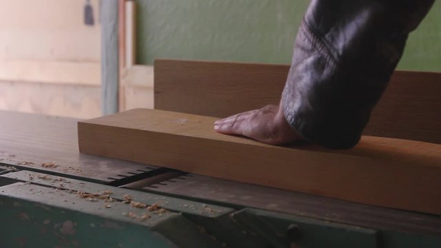 Carpenter works on circular saw, woodworking machine in the carpentry workshop 