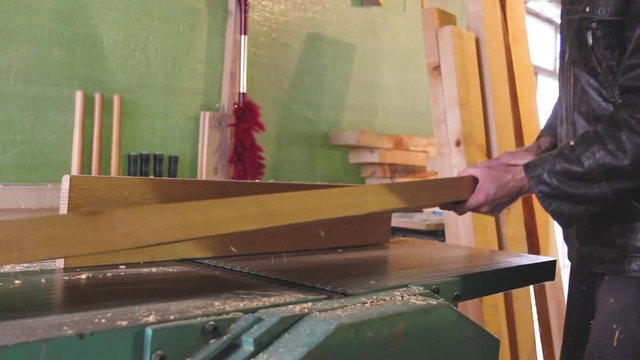 Carpenter works on circular saw, woodworking machine in the carpentry workshop 