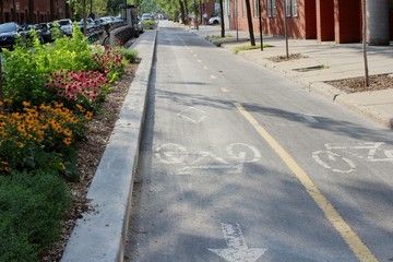 Empty bicycle lane in the city of Montreal in a trendy hipster neighborhood with asphalt painted with bike signs.
