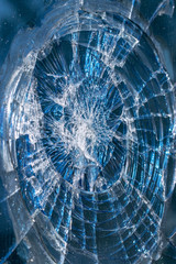 Background texture: dirty broken glass of a building with small fragments. Photo under natural light on the street. Bright blue color.