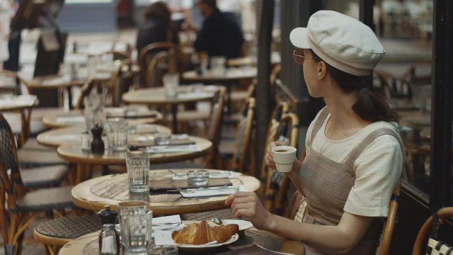 Attractive woman having breakfast in a cafe in the morning