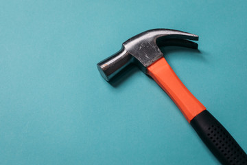 metal hammer with an orange handle on a blue background close