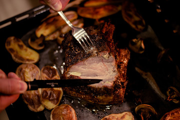 Man cut roast pork belly, check readiness on baking tray cooked in oven. Traditional country cuisine. Baked fat meat. Cooked meal. Home made food. Rustic style. Gastronomy concept. Appetizing dinner