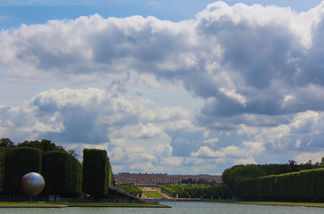 A lonely view of Versailles park, France. The geometric combination of green trees, grass areas and...