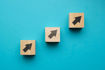 Financial growth concept with icons on wooden blocks.