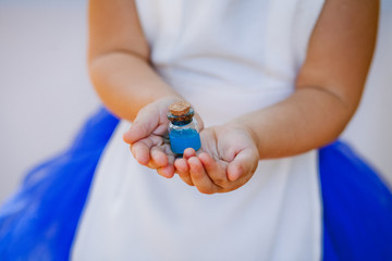 Little bottle with elixir in the hands of a little girl