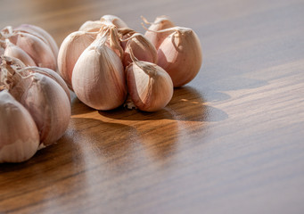 Garlics on wood table background with natural light,Garlic is a spice that gives the smell and taste to food,Also helps to reduce cholesterol in the blood,Control sugar levels in people with diabetes.