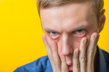 Blond young man shocked tired. Gesture. Close portrait. Isolated yellow background. photo
