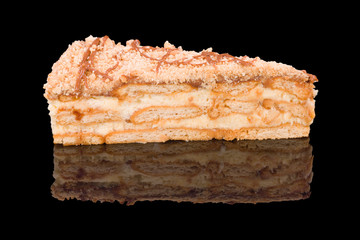 Piece of biscuit torte, isolated on black background.