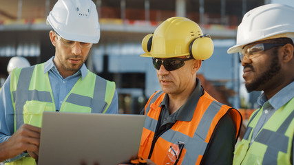 Diverse Team of Specialists Use Laptop Computer on Construction Site. Real Estate Building Project with Civil Engineer, Architectural Investor, Businesswoman and Worker Discussing Blueprint Plan