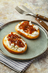 Canape or crostini with toasted baguette, cottage cheese, fig jam