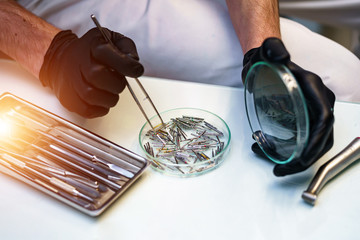 Metallic dentist tools. Dentist instrument sterille in dentist`s hands.