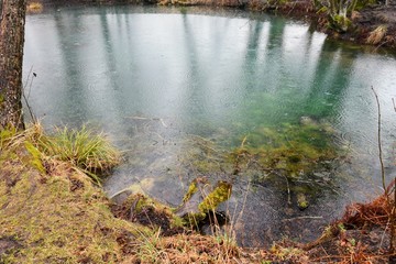 Sacred Spring with healing water. Blue Krinitsa. Place of pilgrimage for Christians. Holy water. Landmark of Belarus. Amazing blue water in the holy lake. Water surface with rain drops.