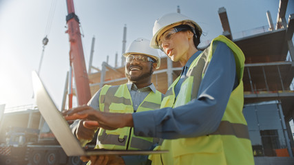 Two Specialists Inspect Commercial, Industrial Building Construction Site. Real Estate Project with...
