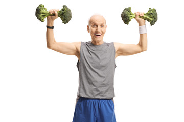 Elderly man in sportswear lifting broccoli instead of weights