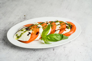 caprese with tomato slices and herbs served with pesto