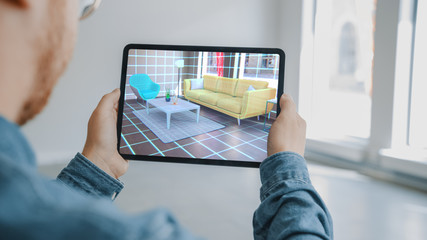 Decorating Apartment: Man Holding Digital Tablet with AR Interior Design Software Chooses 3D...
