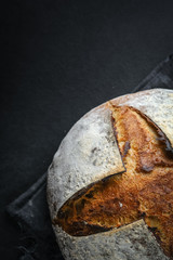 .Bread. Homemade whole grain bread on a dark napkin on a dark background copy space.