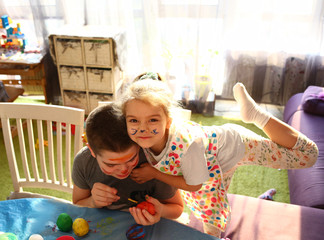 Funny kids with stained faces having fun at home in the kitchen. Brother and little sister. Funny. Creative concept. Mess at home. Normal quarantined life. Lifestyle COVID-19