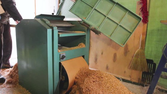 Carpenter is straightens the board's, plank surface on machine, to make them in parallel.