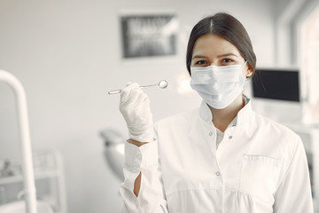 Woman in a uniform. Doctor working at the clinic. Dentist holds a tools in her hands